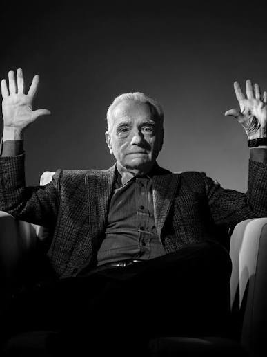 Martin Scorsese with his hands raised